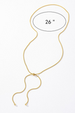Gold snake chain lariat necklace with a gold bead slider. Necklace is 26 inches long