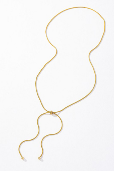 Gold snake chain lariat necklace with a gold bead slider. Necklace is 26 inches long