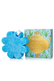 A blue flower-shaped sponge bath bomb next to its illustrated packaging box on a white background. The box features a gold label and tropical jungle illustrations.