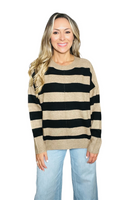 Woman wearing a black and tan striped sweater with a crew neckline