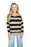 Woman wearing a black and tan striped sweater with a crew neckline