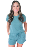 Woman wearing a teal outfit with a matching top and shorts on a white background