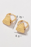 upclose photo of small gold huggie style hoop earrings with a triangular slide that has a hammered texturing with measurement marks  - 0.75 inches 