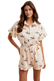 Woman modeling a silky satin feel mallard duck print matching shorts set featuring a button down collared top with ruffle sleeves and relaxed fit drawstring shorts with ruffle hem details.