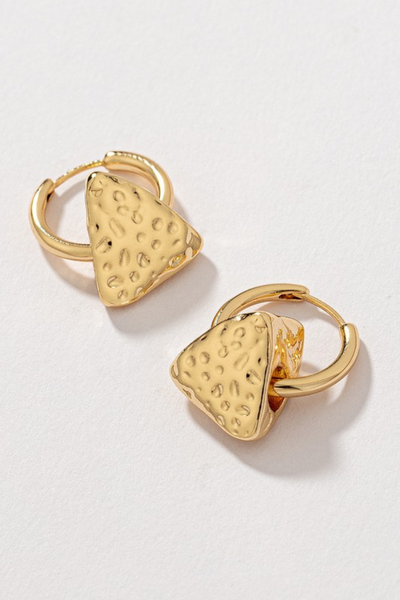 upclose photo of small gold huggie style hoop earrings with a triangular slide that has a hammered texturing