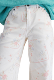Close up of white twill pants with pastel floral cross stitch inspired print, button and zip fly closure, front pockets, and relaxed fit.