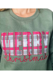 Upclose photo of an olive green sweatshirt with MERRY in a patch and Christmas in a scripted embroidered font.