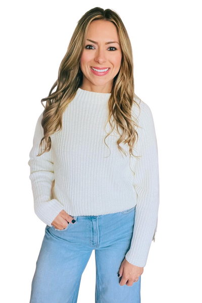 Woman wearing an ivory ribbed mock turtleneck sweater with jeans 