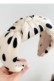Knotted black and white polka dot headband with soft fabric and top knot detail