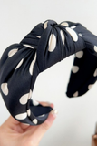 Knotted white and black polka dot headband with soft fabric and top knot detail