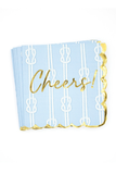 A stack of light blue party napkins with white rope and knot patterns, gold foil script reading 'Cheers!', and a gold scalloped edge, shown on a white background.