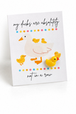 Quacks of Kindness greeting card featuring the saying "My ducks are absolutely not in a row," a white duck with yellow ducklings, colorful polka dots, and a 3D yellow duck accent.