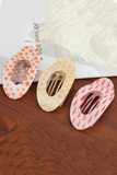 Assorted lay flat oval hair claw clips with floral, sun, and fish print designs