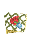 A stack of square paper napkins with scalloped gold edges, featuring a white background with a green geometric lattice pattern, a red poinsettia, green garland, and a blue-and-white ceramic pot.