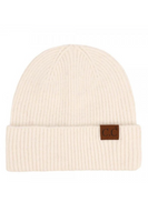 Ivory ribbed knit beanie on a white background. Beanie is folded over with a tan tab in on the right side of the beanie that reads C.C.
