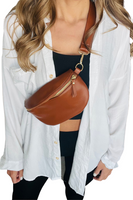 Camel colored leather bum bag worn crossbody on a female with a white button down, black crop top and black pants