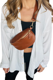 Camel colored leather bum bag worn crossbody on a female with a white button down, black crop top and black pants