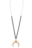 Long gold chain necklace with black and gold beading with a  gold crescent pendant. Necklace is 32.5 inches with a 3 inch extender