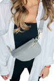 Gray colored Leather bum bag worn crossbody on a female with a white button down, black crop top and black pants