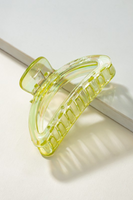 Iridescent lime green crescent shaped hair claw clip on a white background.