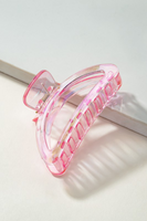 Iridescent lime pink crescent shaped hair claw clip on a white background.