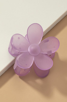 up close photo of a lavender frosted colored daisy hair claw clip on a white and tan background 
