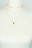 Photo of a gold layered chain necklace on a white jewelry mannequin. 