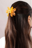 Photo of orange checkered patterned daisy hair claw clip in a brunette woman's hair