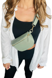 Sage colored Leather bum bag worn crossbody on a female with a white button down, black crop top and black pants