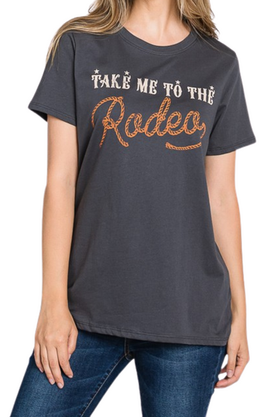 charcoal t-shirt with "take me to the rodeo" in white and brown font. Rodeo graphic is in a roped cursive font.