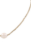 up close picture of gold strung beaded necklace with a single faux baroque style pearl